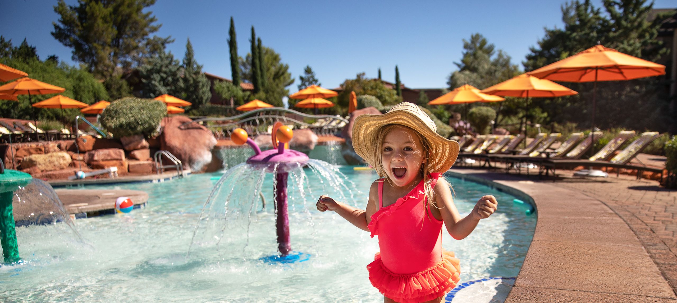 little girl laughing and wading in the pool
