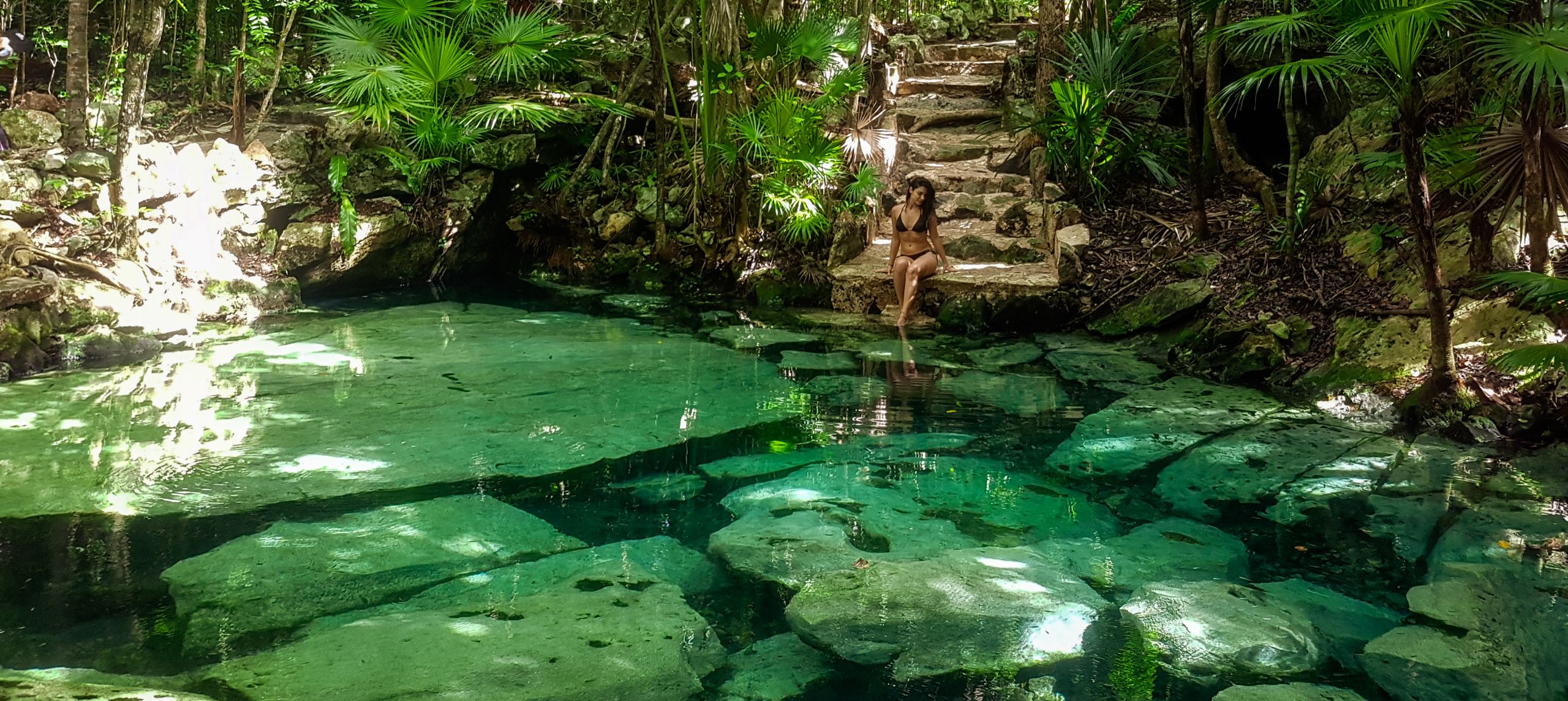 Woman sitting a pool in forest