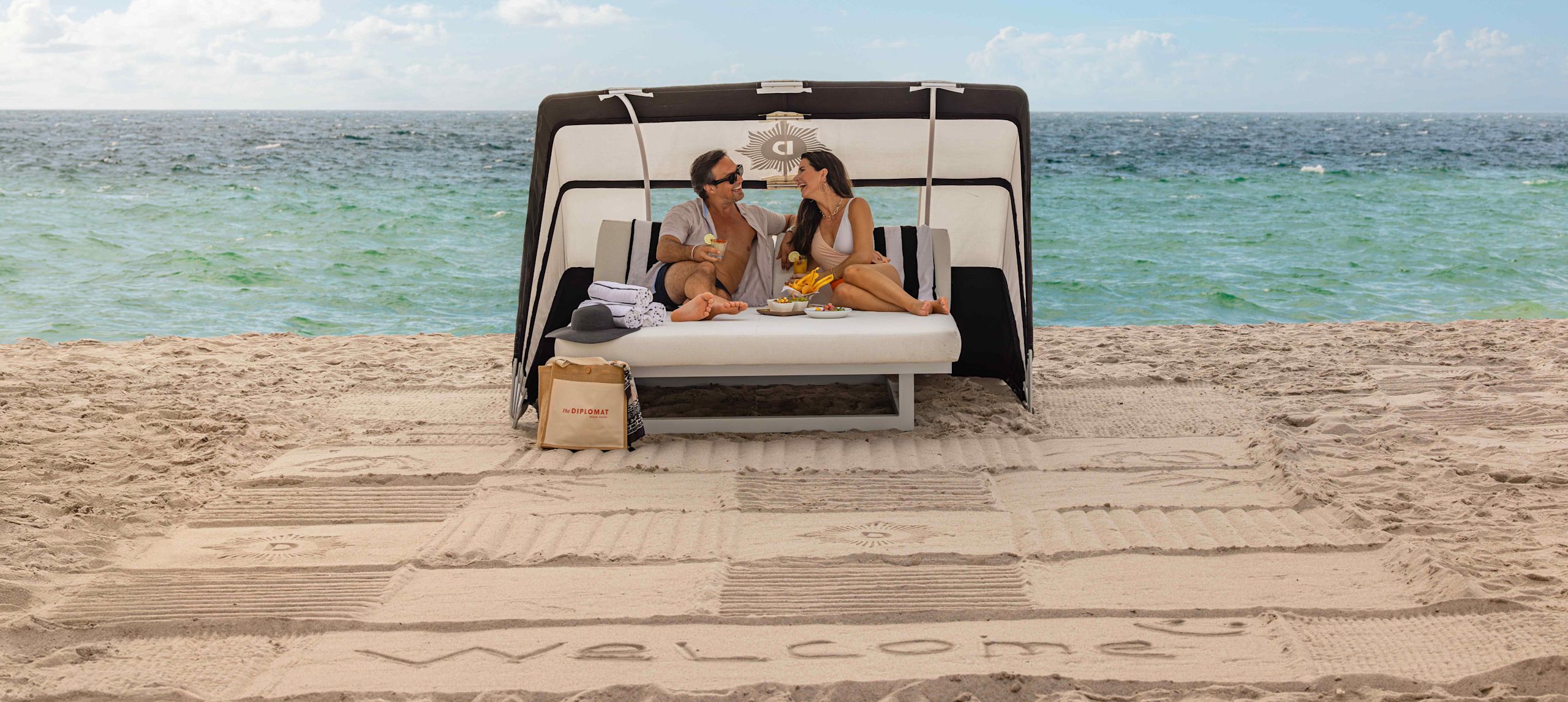 Couple Talking on a Day Bed at the Beach