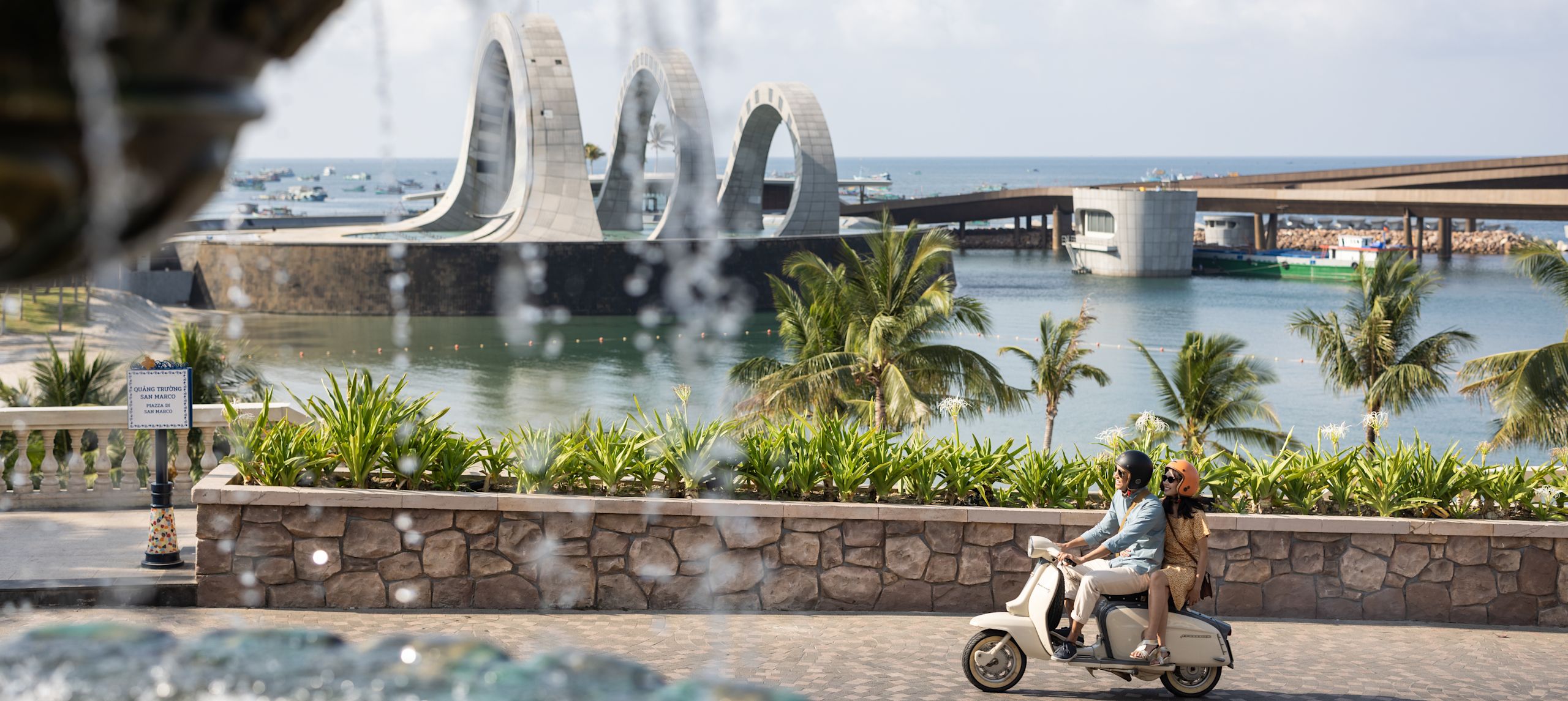 fitur air dengan orang-orang di atas skuter di latar belakang