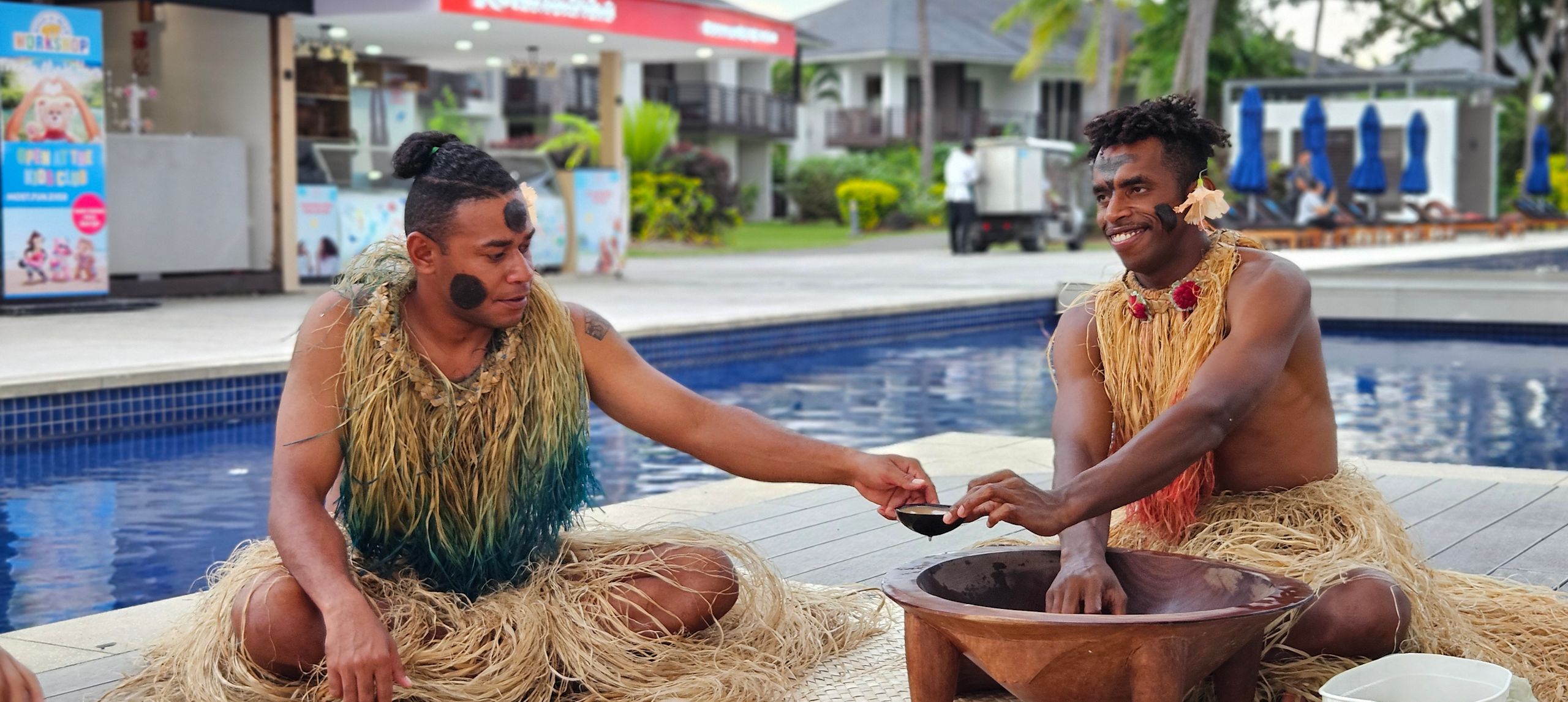 Zwei Personen in traditionellem Kleid mit Zeremonie am Swimmingpool