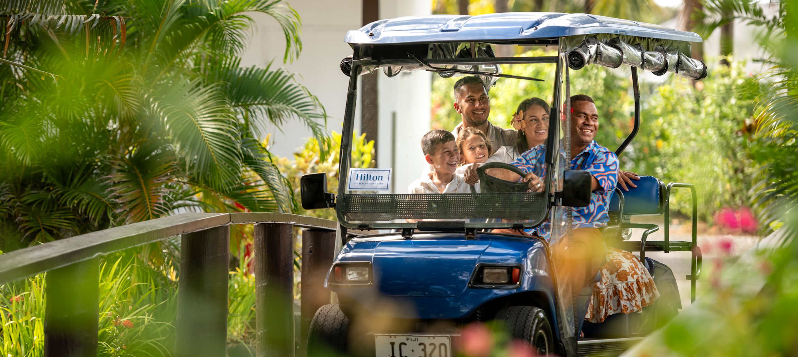 Family being driven in golf cart by staff member