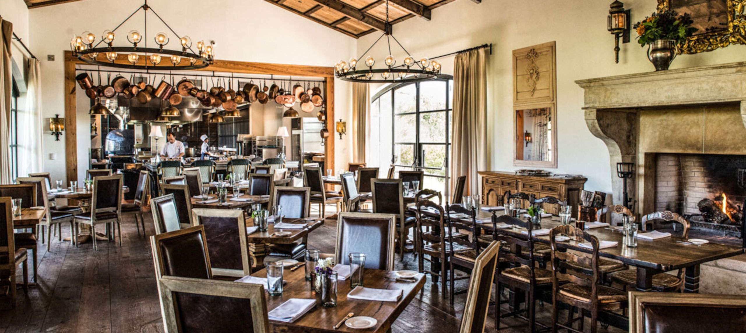 招牌餐厅座位布置，背景中有厨师在准备