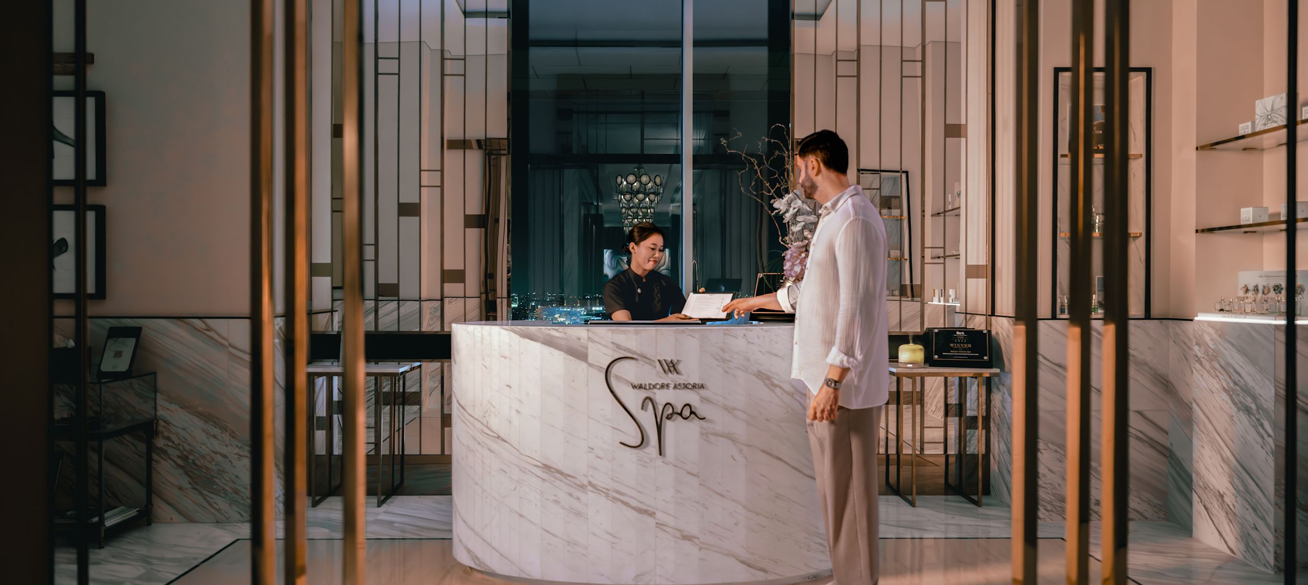 Spa reception with man handing paper across to staff member