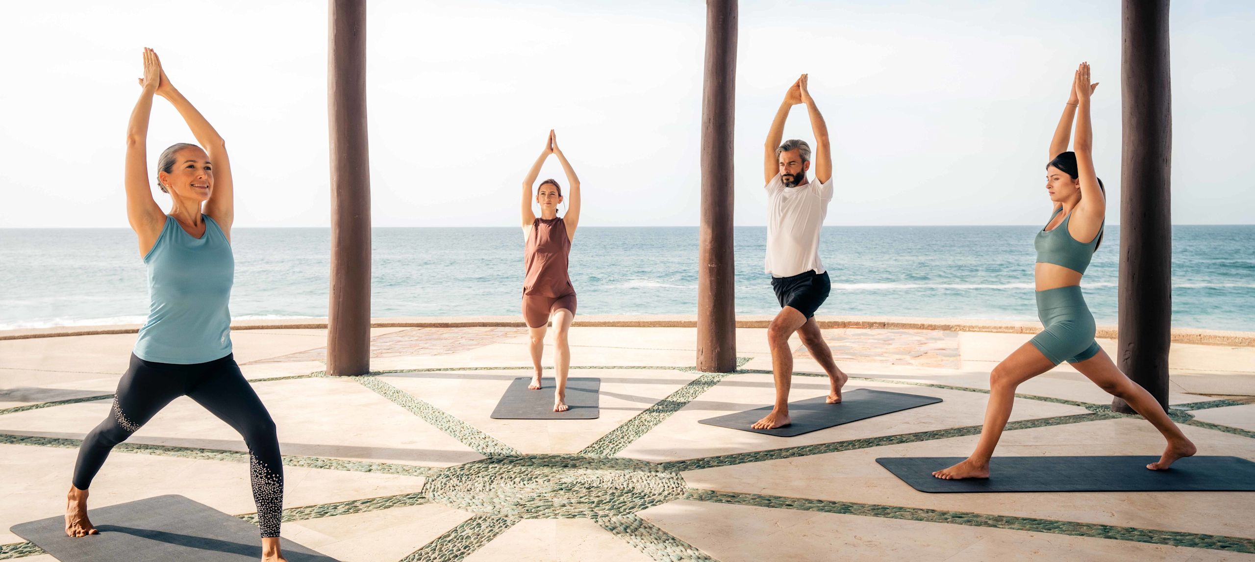 海を背景にヨガを楽しむ人々
