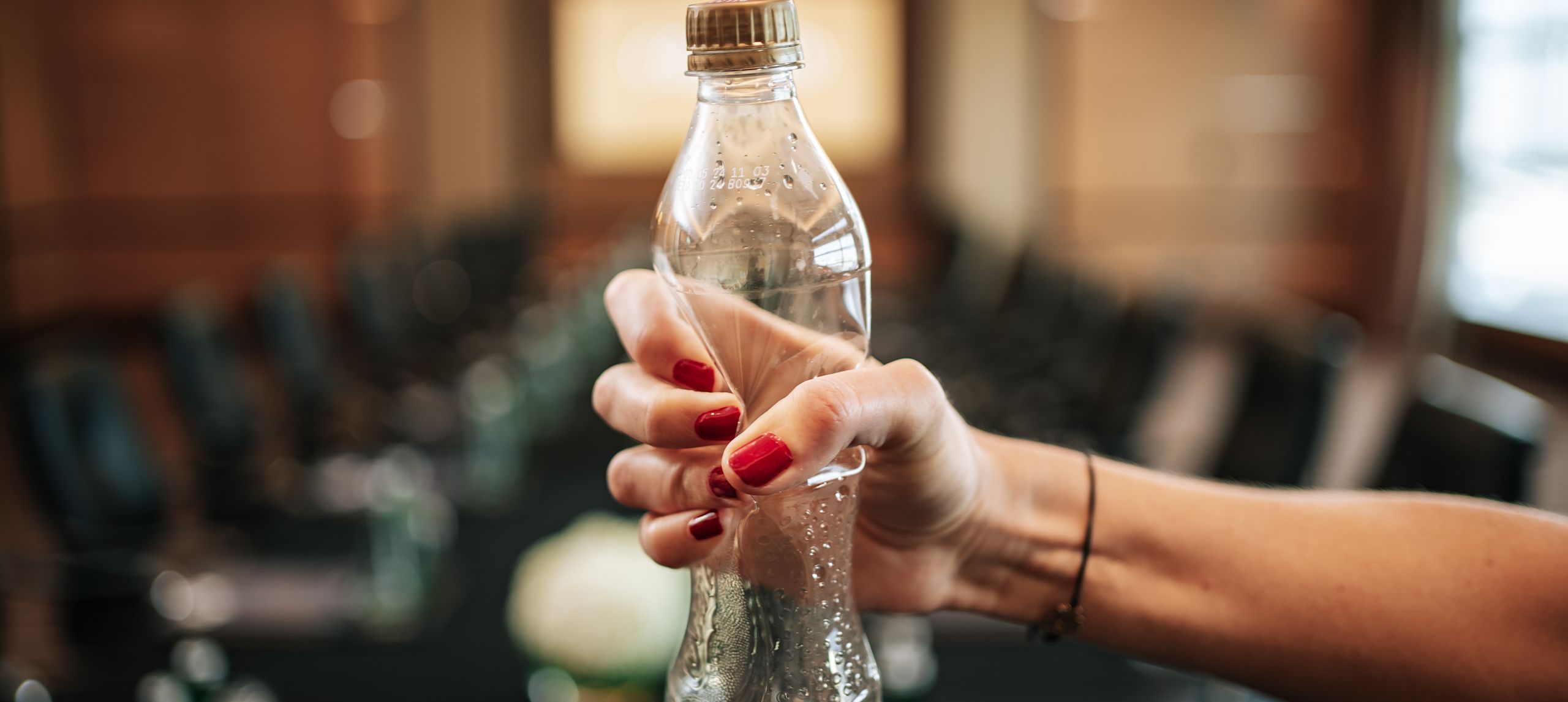 Obrázek udržitelného životního stylu s osobami drtícími plastovou láhev před sebou