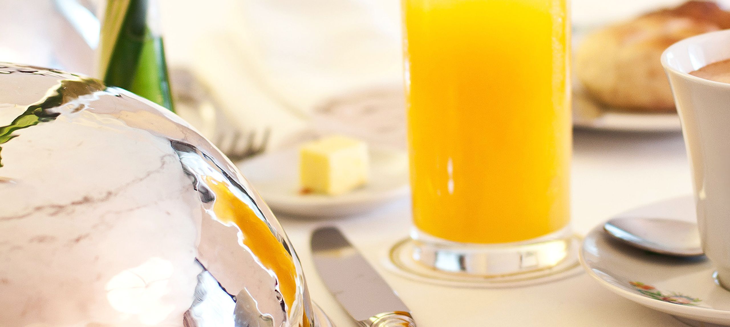 Primer plano de un vaso de jugo de naranja en una mesa de comedor