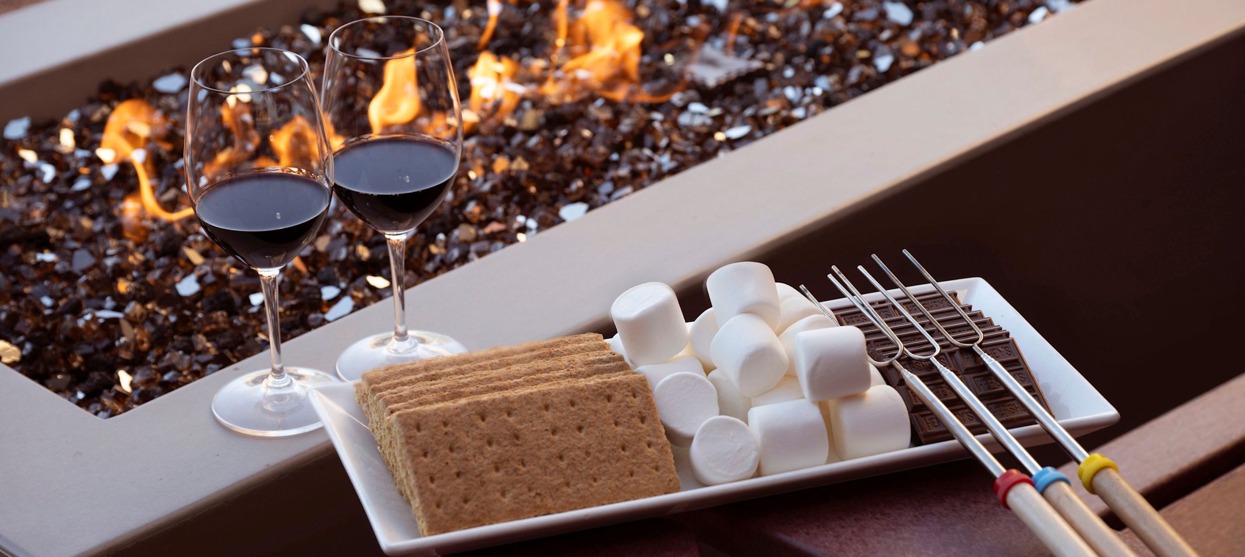 Shared firebowl with smore ingredients and wine.