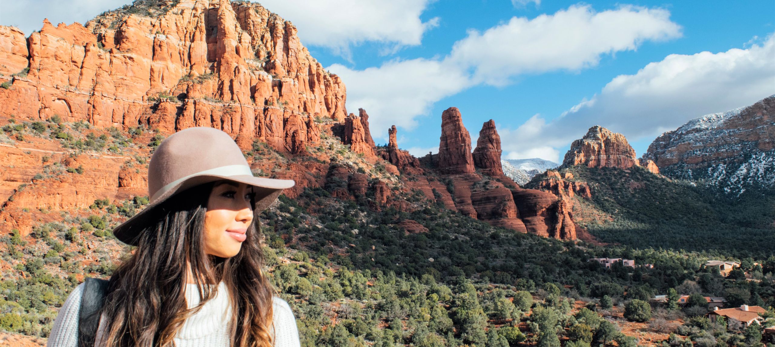 Mujer con paisaje de montañas de rocas rojas detrás de ella