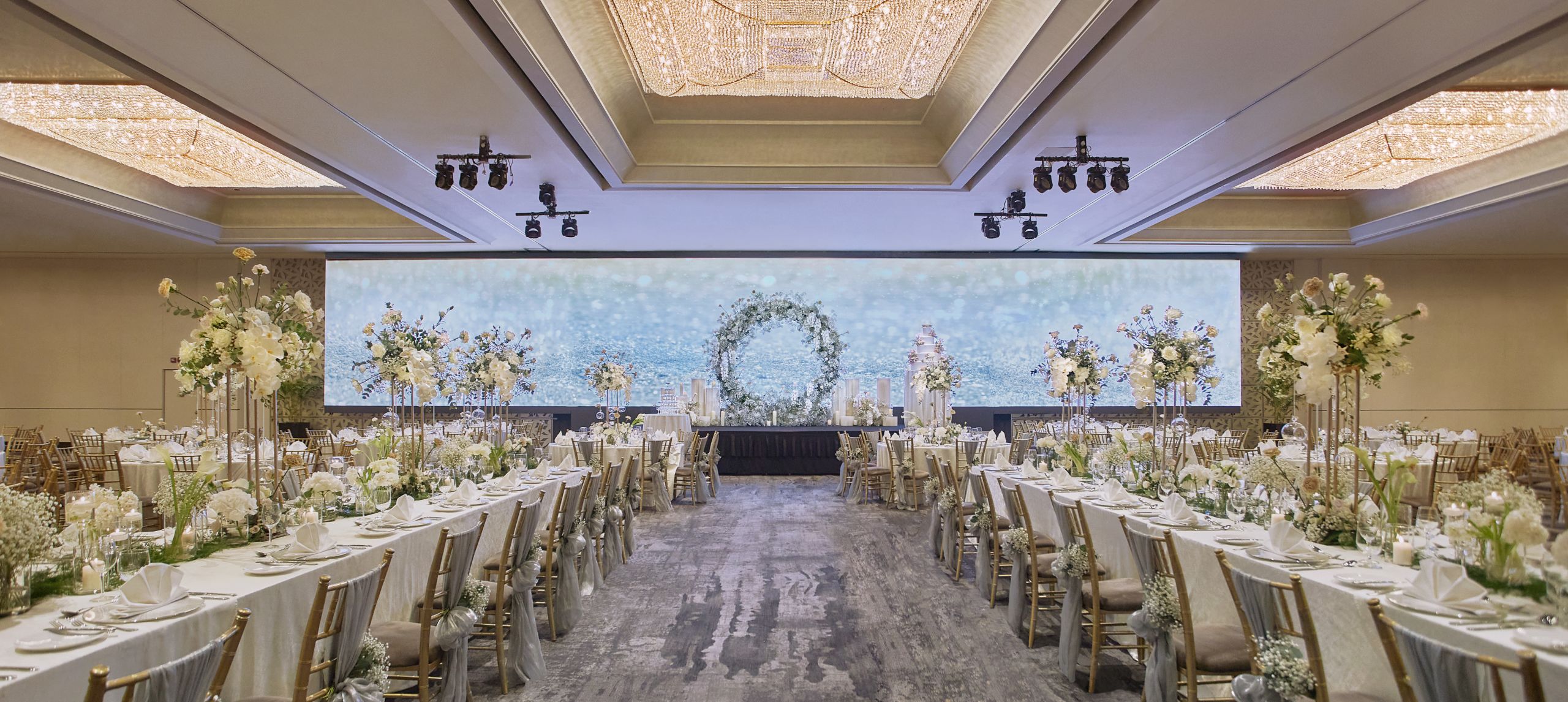 ballroom with long dining tables setup for wedding