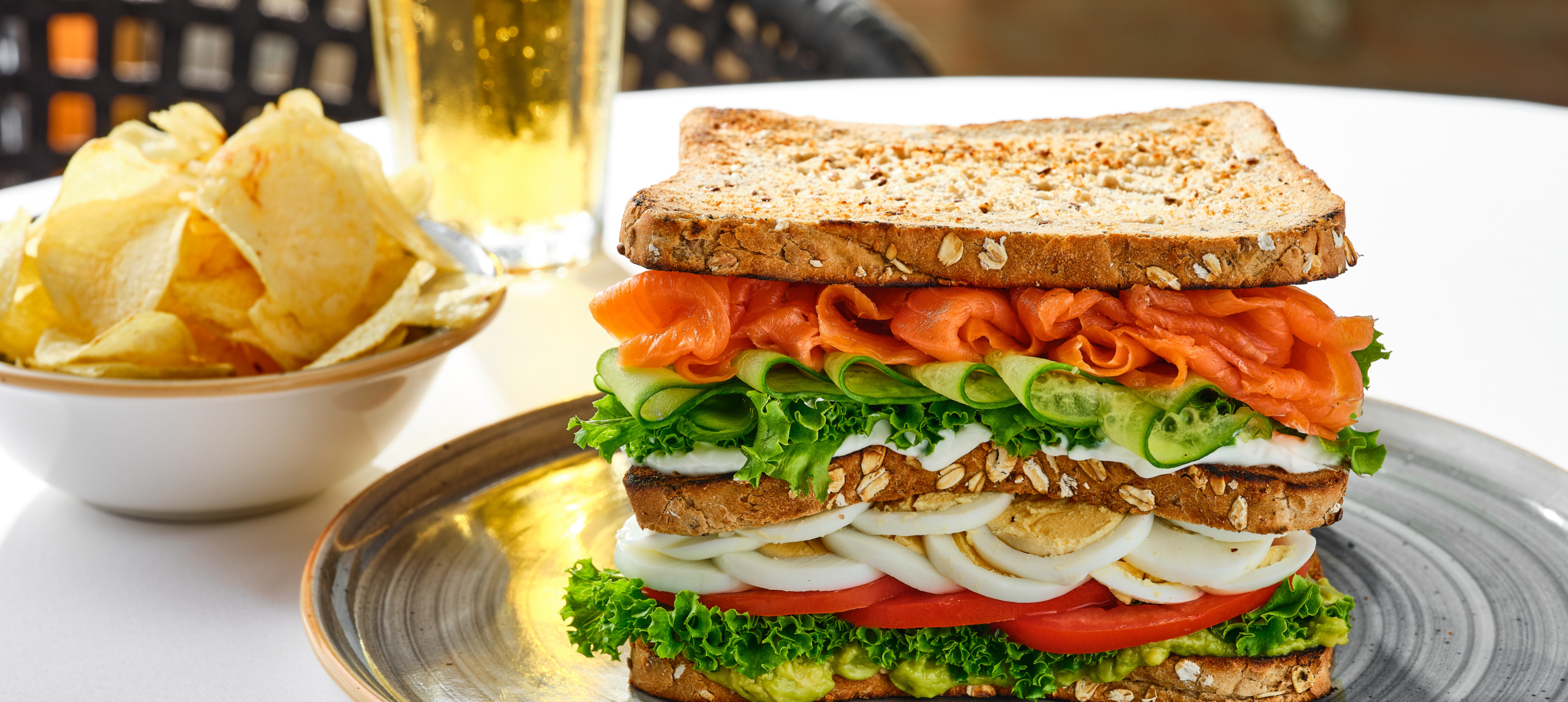 a Club Sandwich, Chips and a Drink on a Table