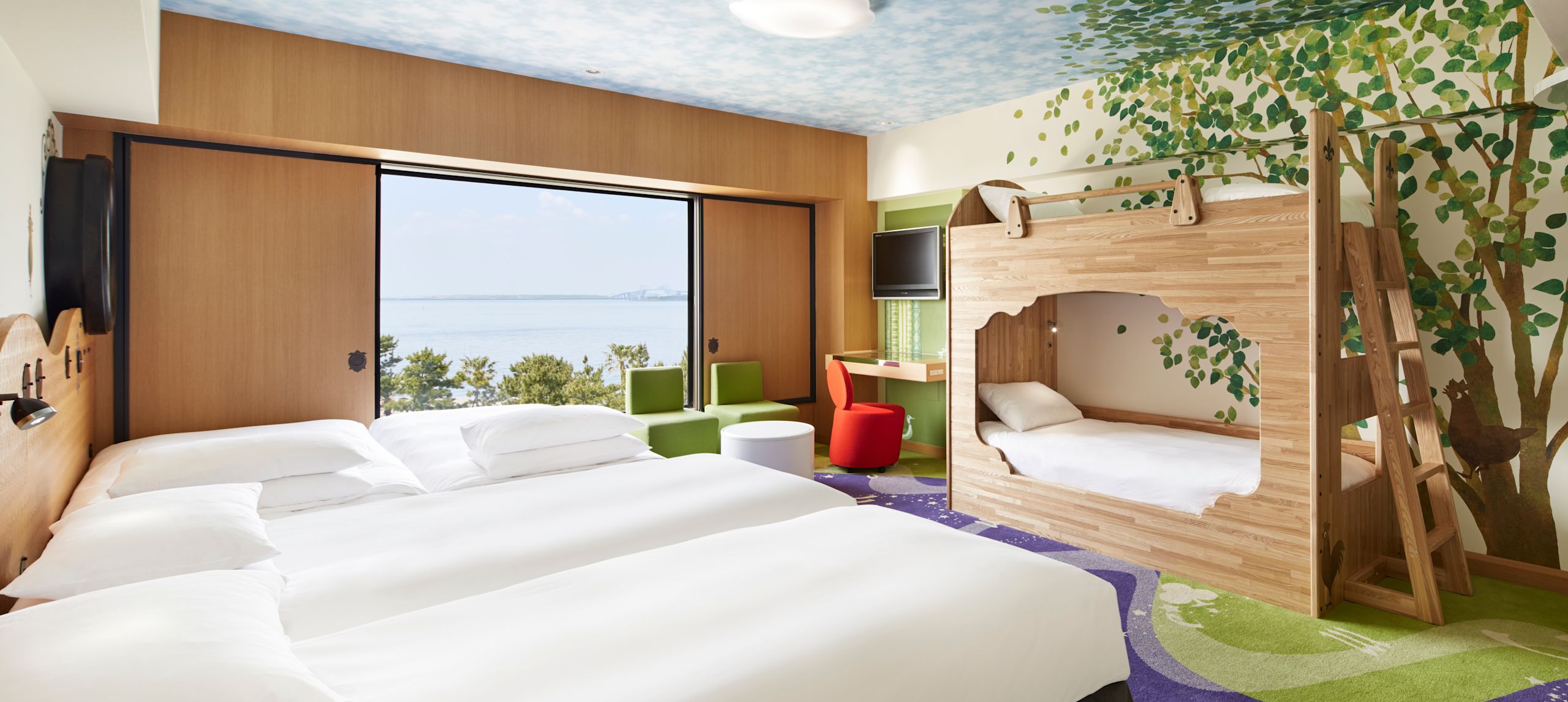 Familjevänligt Magic Ocean-rum med dekorativ väggmålning, sängar, TV och stort fönster