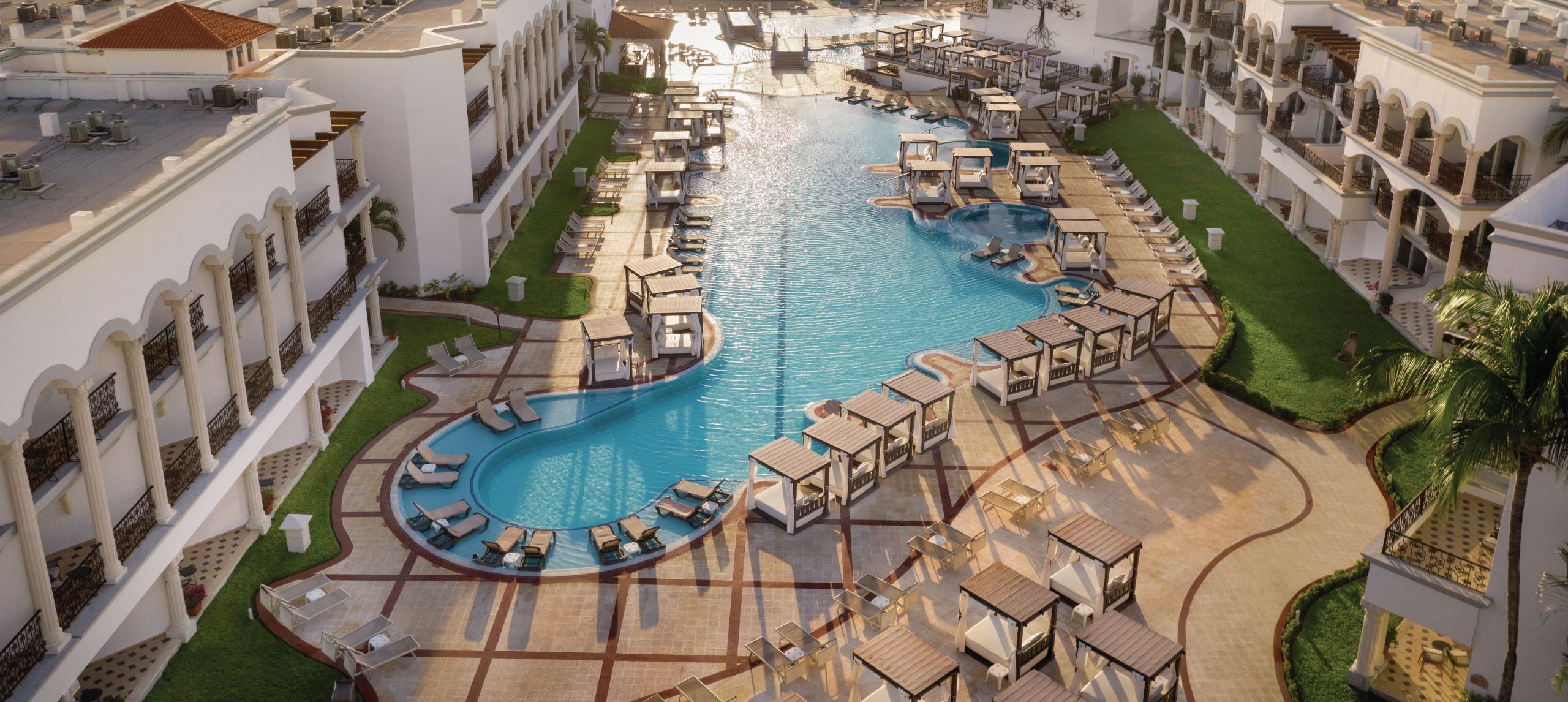 Vista aérea de la fachada del hotel con una amplia piscina