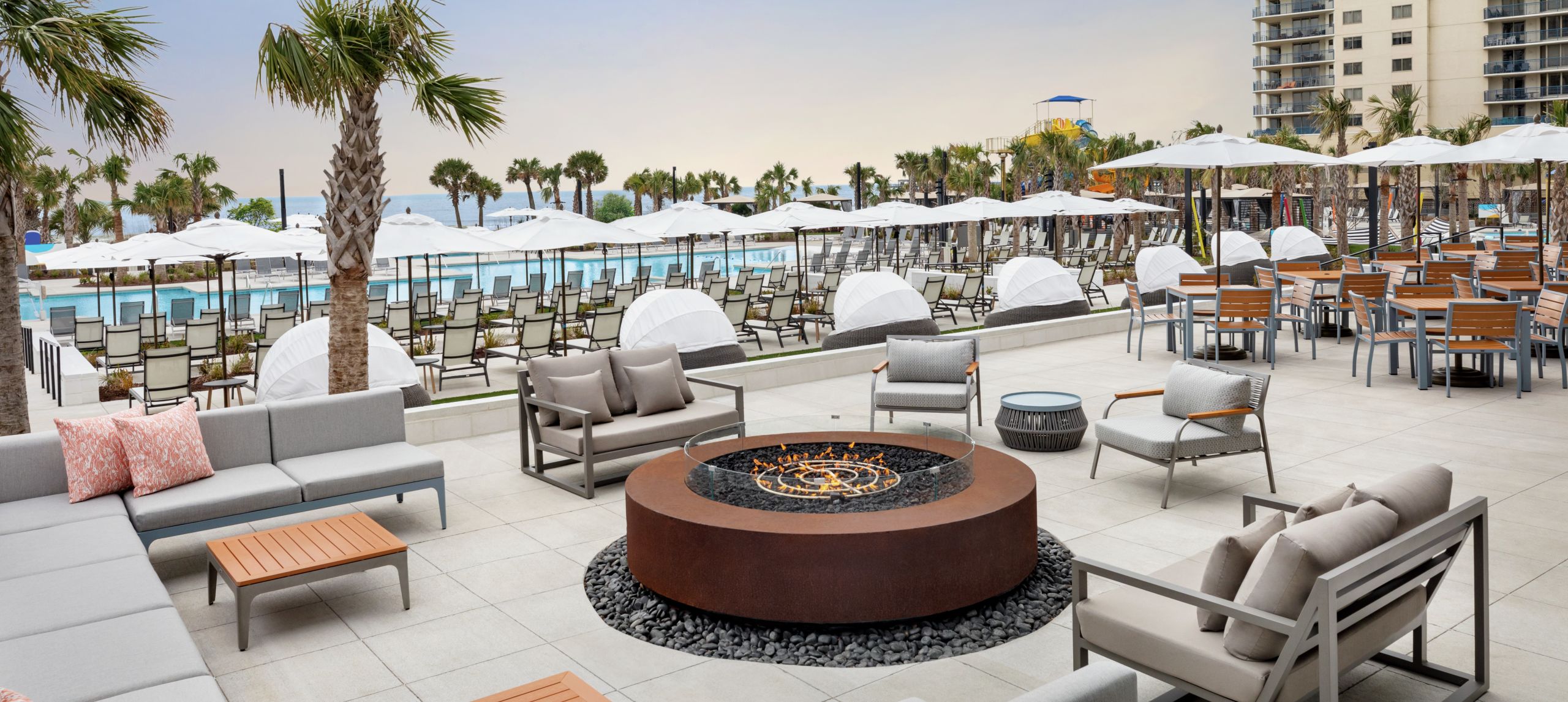 Beautiful outdoor brewery terrace featuring comfortable seating with outdoor fire pit and ocean views