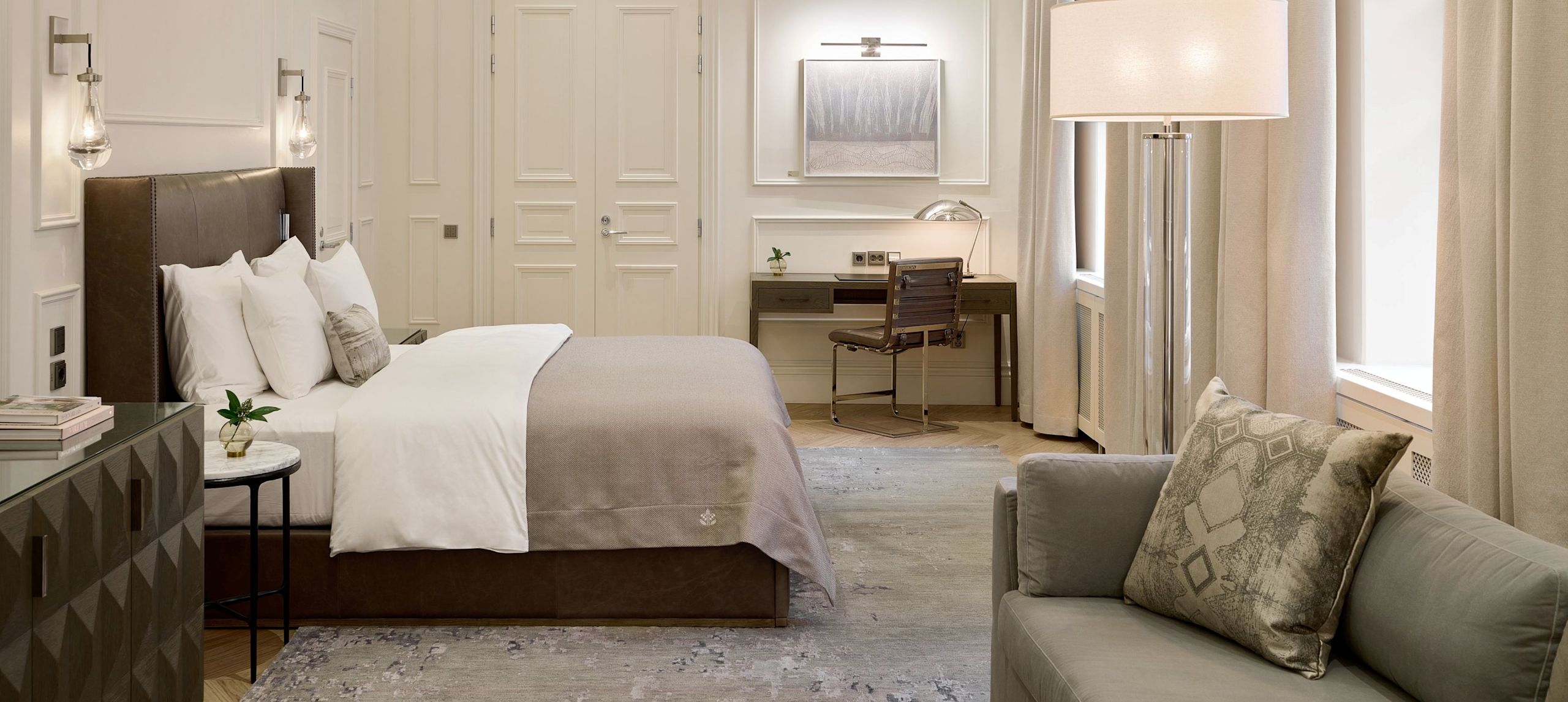 Quarto com cama, área de estar e mesa de trabalho, transição
