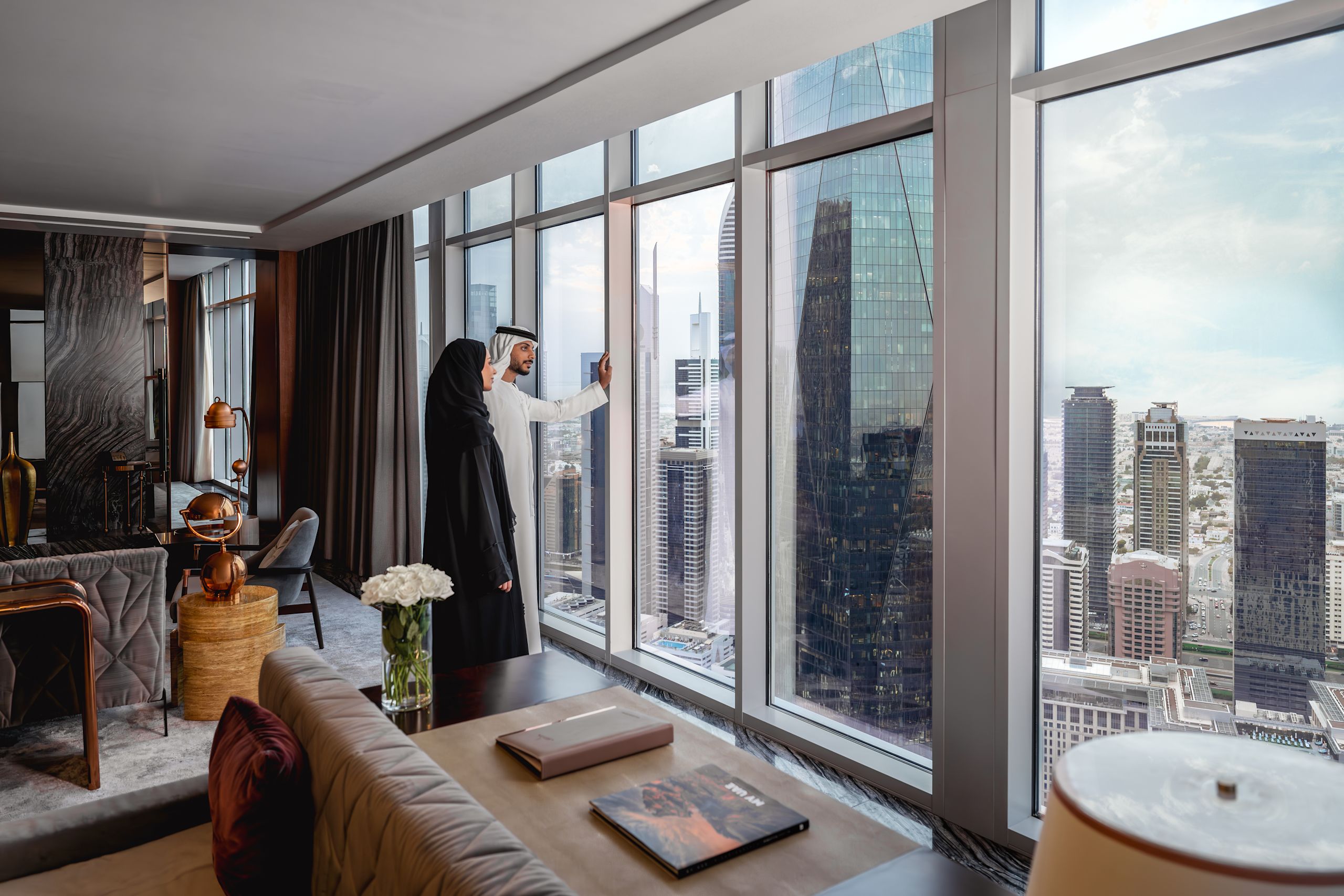 Man and woman in guest room looking out at city view