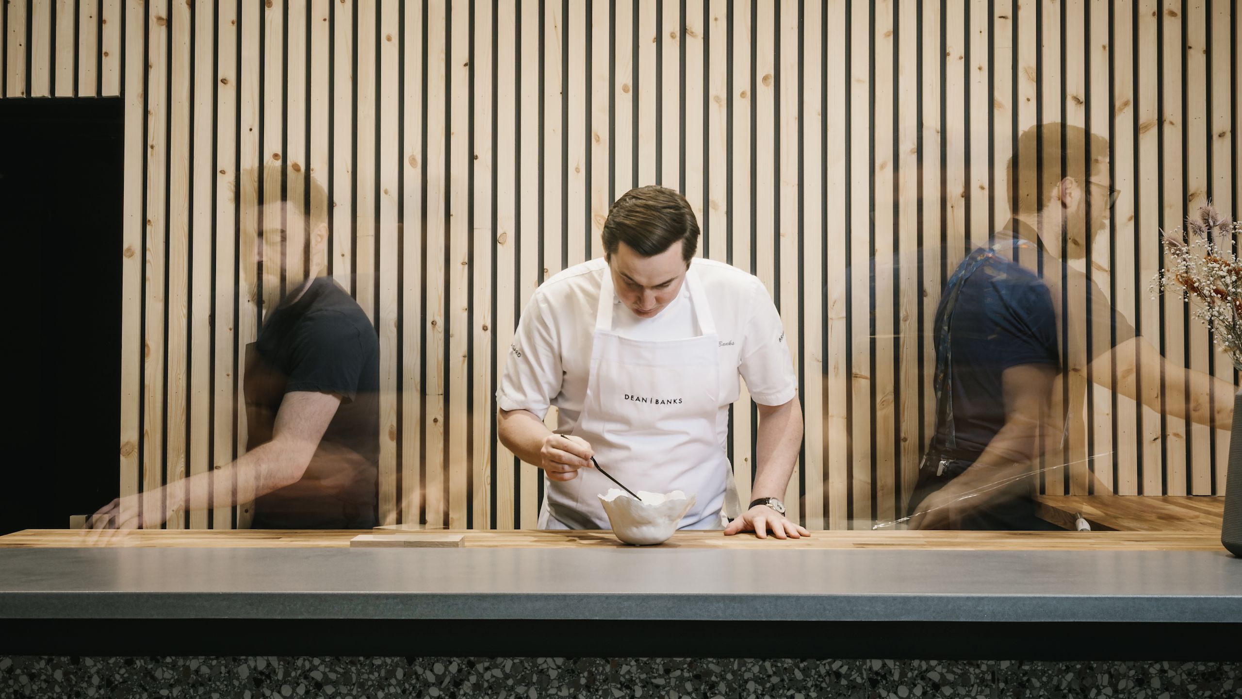 man in apron stirring in a bowl-transition
