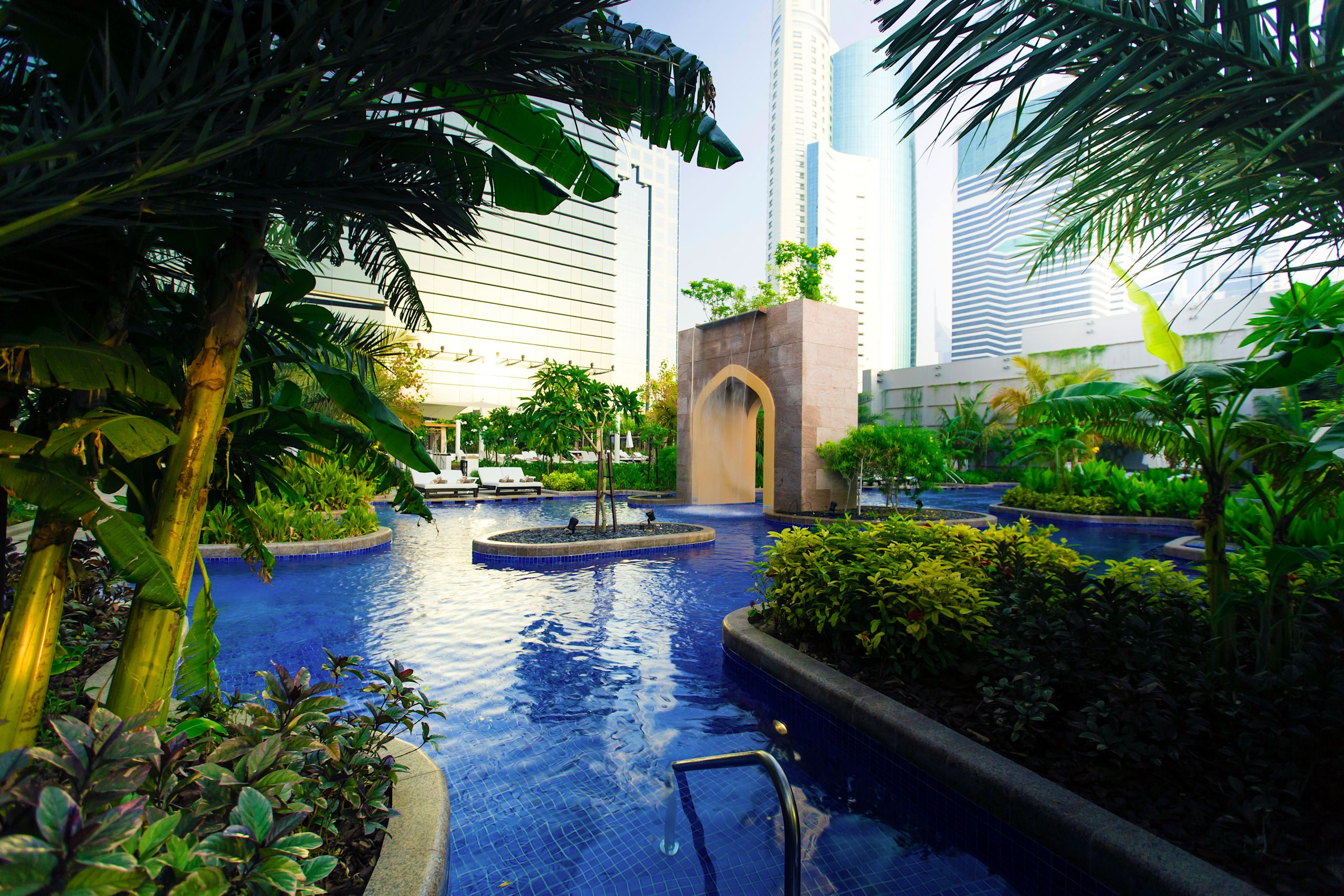 Outdoor Pool Area with Cascade and Gardens with Palm Trees