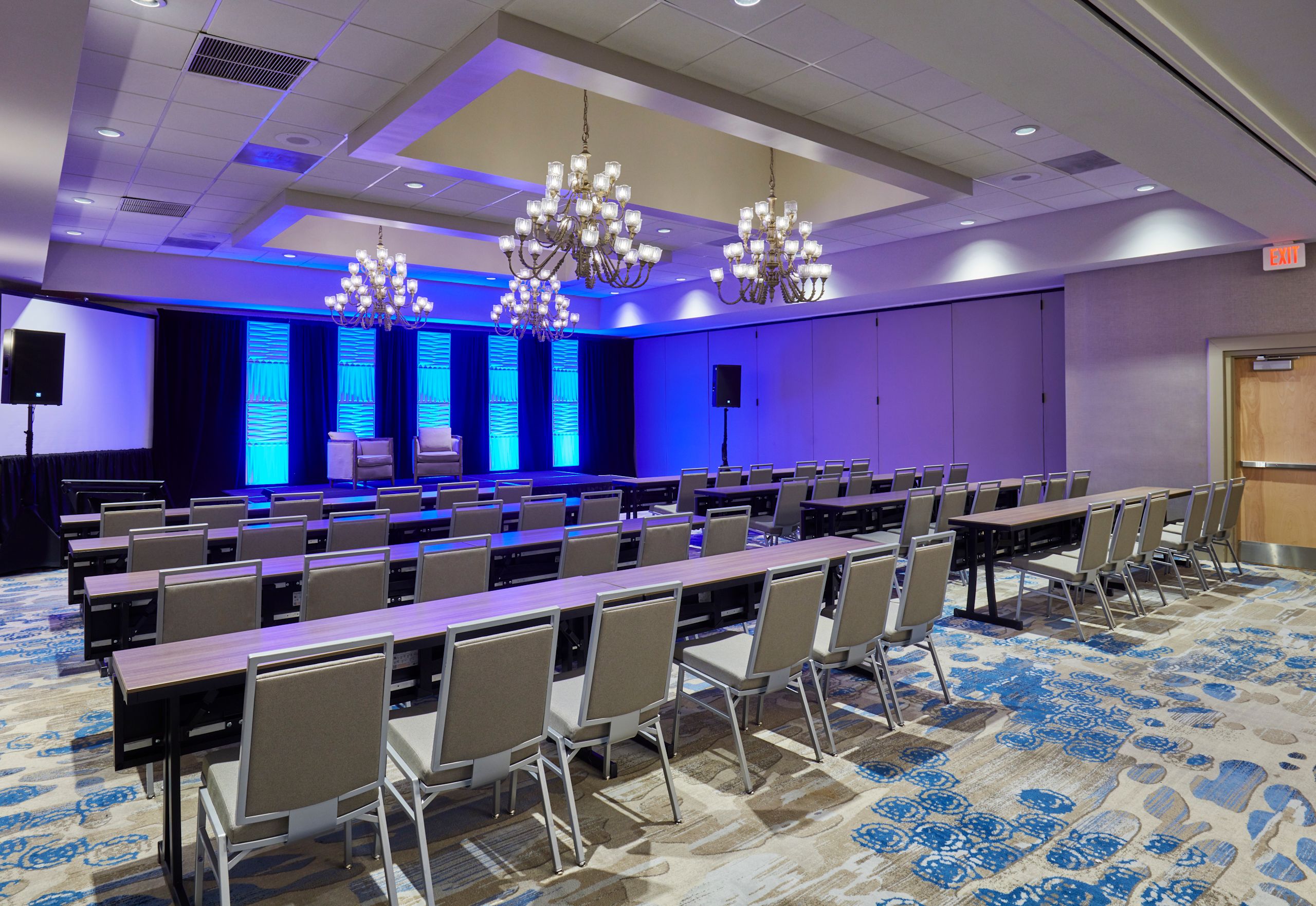 Salón de fiestas con montaje tipo aula y pantallas para proyector