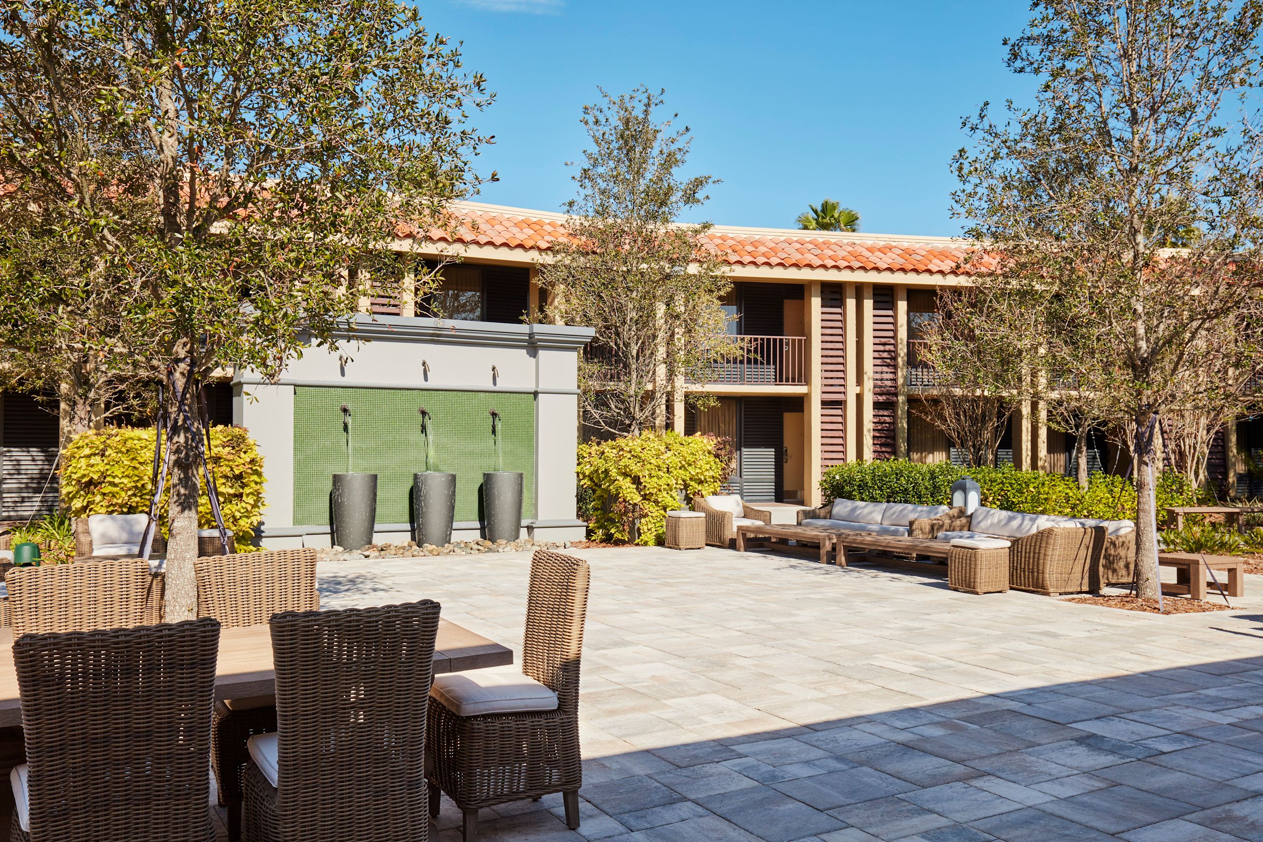 Área del jardín del hotel con sillas, mesas y fuente