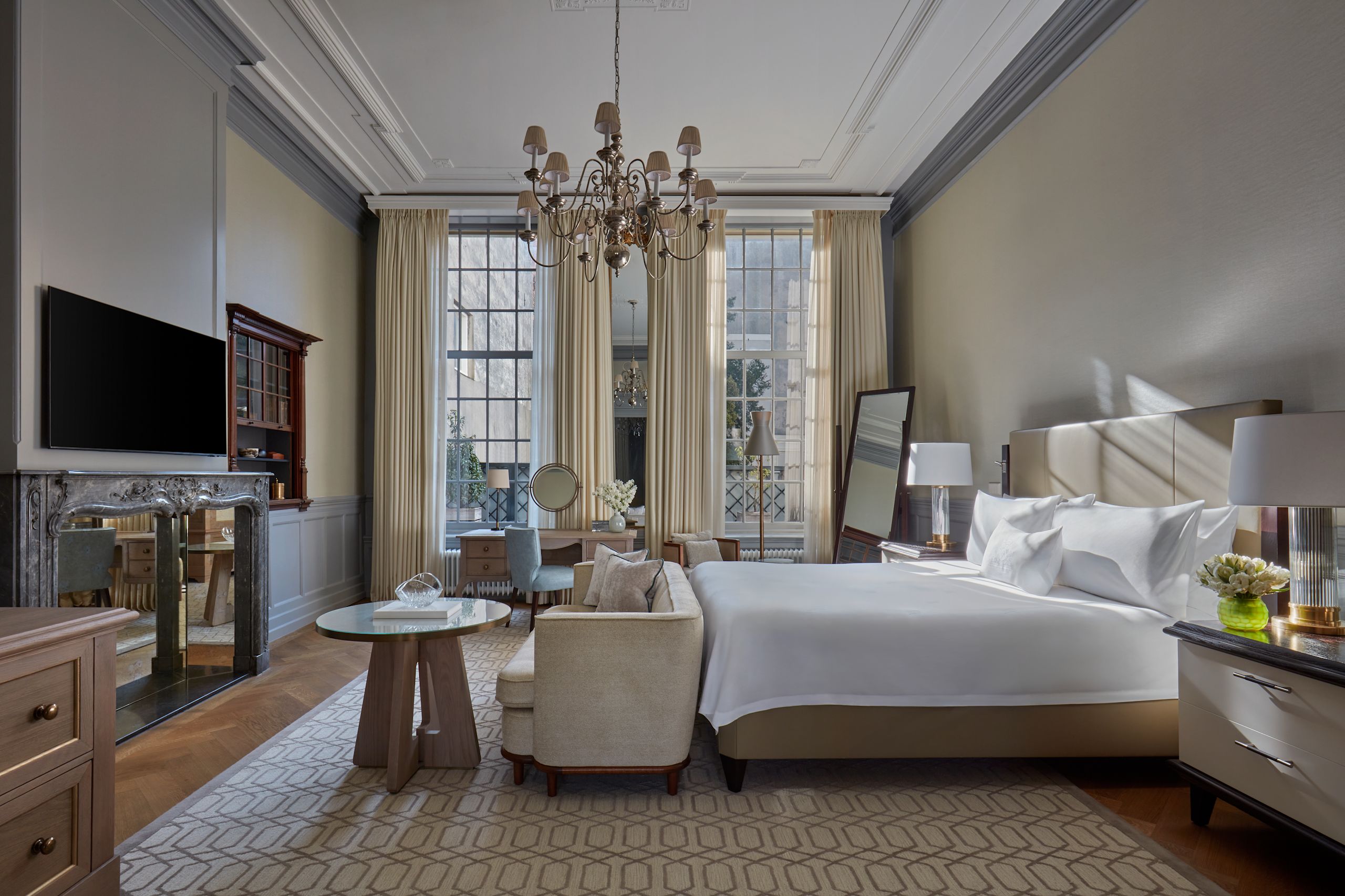 Large Bed, and Lounge Area in a Suite with TV and Large Windows