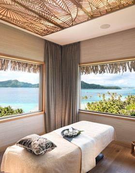 Tempat Tidur Pijat dengan Minyak pada Baki, Lilin, dan Pemandangan Air