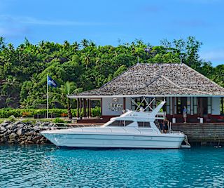 People Enjoying a Hilton Boat Ride next to a Building on the Water