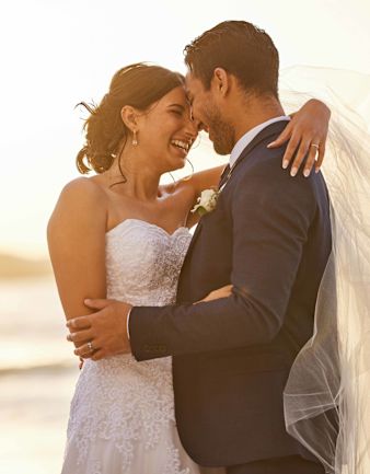 bride and groom on the beach hugging