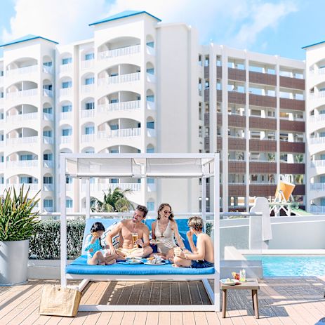 Family sitting in a large covered lounge seat at the Chala Sky Bar.