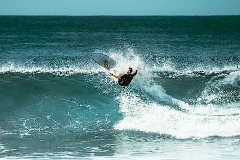A man riding a wave on a surfboard in the ocean