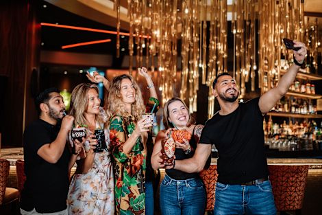 people with drinks taking a selfie