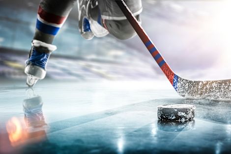 Hockey player action shot close up of stick and puck