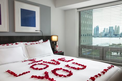 guest room bed with floral arrangement spelling I love you on bed