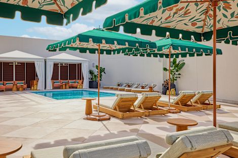 파라솔 아래 카바나 및 라운지 의자가 있는 야외 수영장 공간