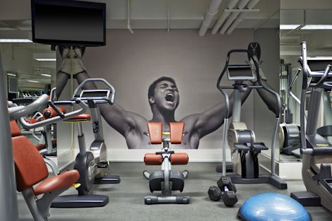 Fitness center with cardio machines, bench and TV