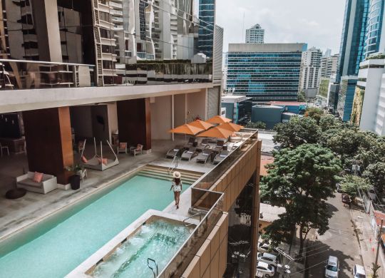 Women hanging out by the pool overlooking the city view