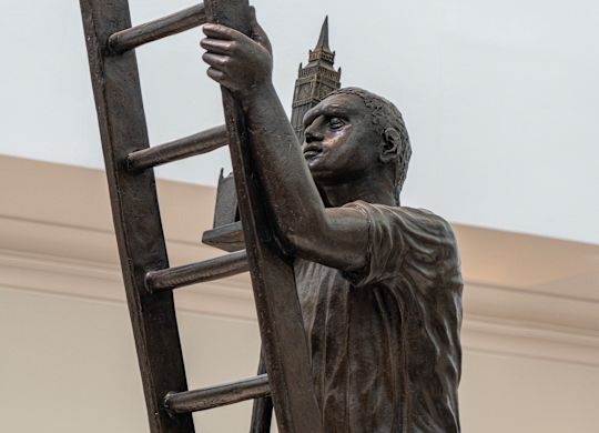 Statue of a Man Climbing a ladder