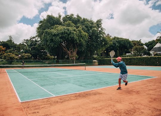 Una persona jugando al tenis en el resort