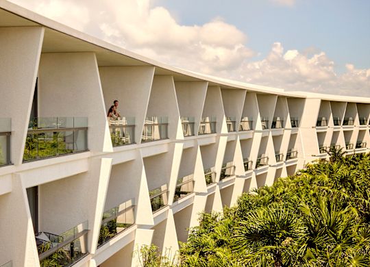 Cuplu admirând priveliștea de la balconul camerei de hotel