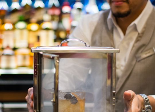 Bartender Holding Case with Cocktail Drink inside steaming
