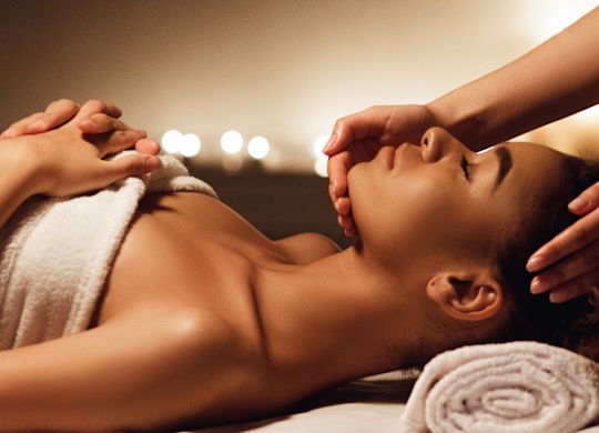 Woman lying on a treatment bed enjoying a facial
