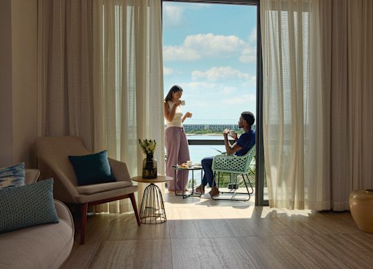 Un homme et une femme prenant un petit déjeuner sur la terrasse de leur suite