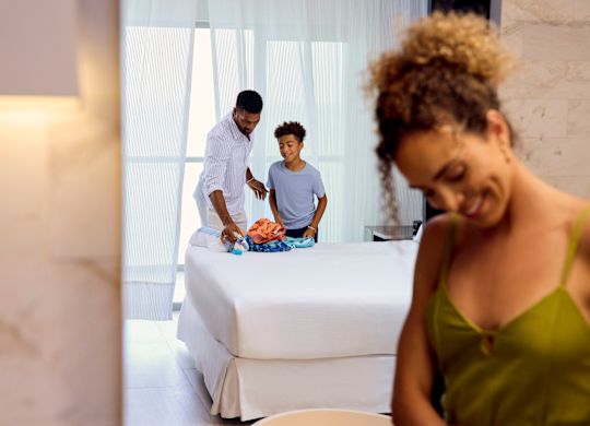 Mamă, tată și fiu despachetându-și valizele în apartament