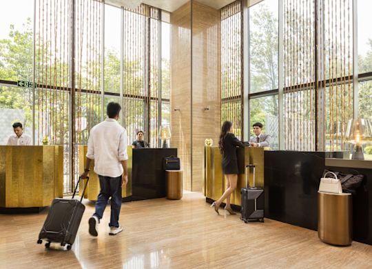 Otel Ön büroya gelen valizlerini çeken kişiler