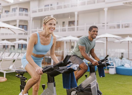 homem e mulher ao ar livre usando bicicletas ergométricas
