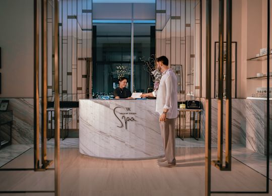 Spa reception with man handing paper across to staff member