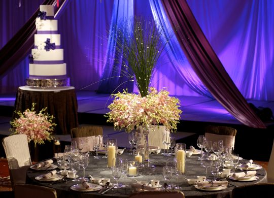 Cake, Flowers and Candles on a Table in a Ballroom Setup for a Wedding Celebration