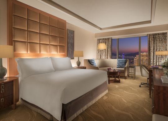 Large Bed in a Guest Room with a Couch and City View at Sunset