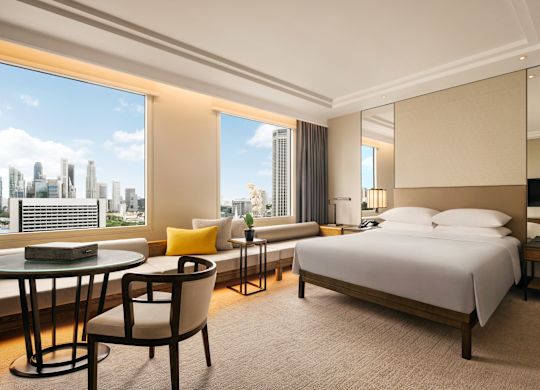 Large Bed and Lounge Area in a Room with City View