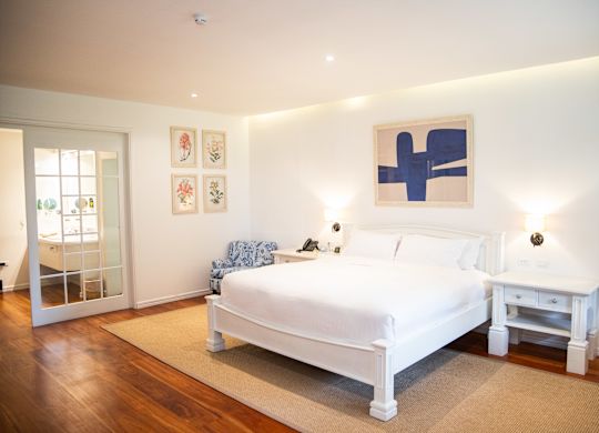 habitación, una cama King, mesa de noche, diván, entrada al baño